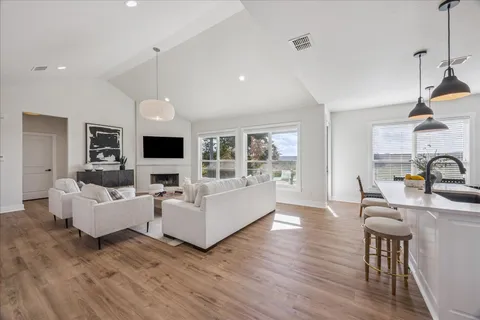a living room with fireplace furniture and a wooden floor