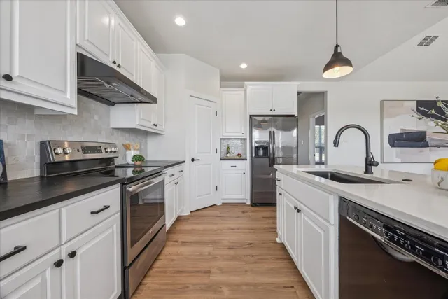 a kitchen with stainless steel appliances granite countertop a sink and cabinets