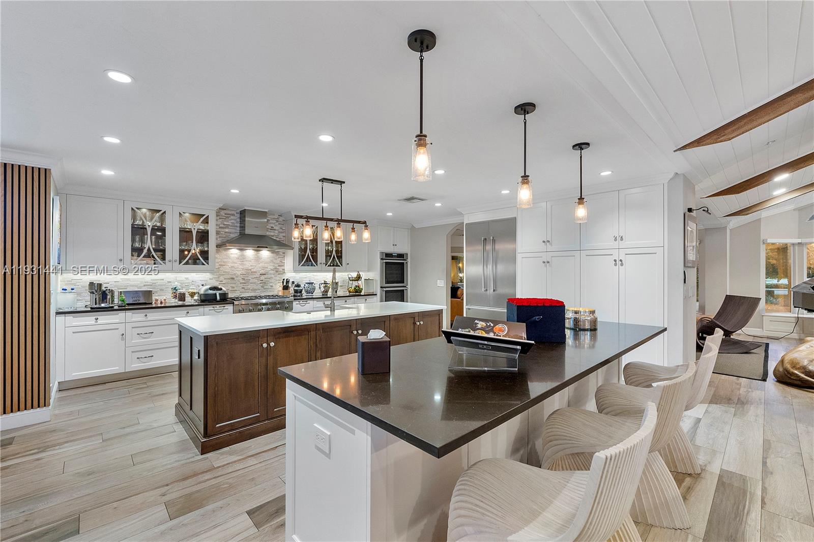 8020 Northwest 47th Drive Coral Springs, FL 33067 - Photo 19 of 83 a kitchen with stainless steel appliances granite countertop a sink dishwasher a stove and a dining table with wooden floor