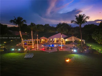 a front view of a house with swimming pool having outdoor seating