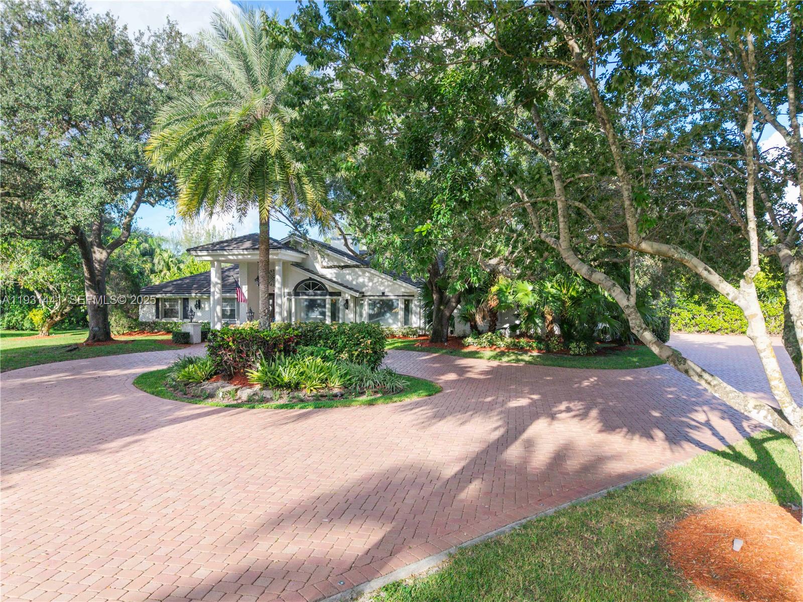 8020 Northwest 47th Drive Coral Springs, FL 33067 - Photo 80 of 83 a front view of a house with a yard and potted plants