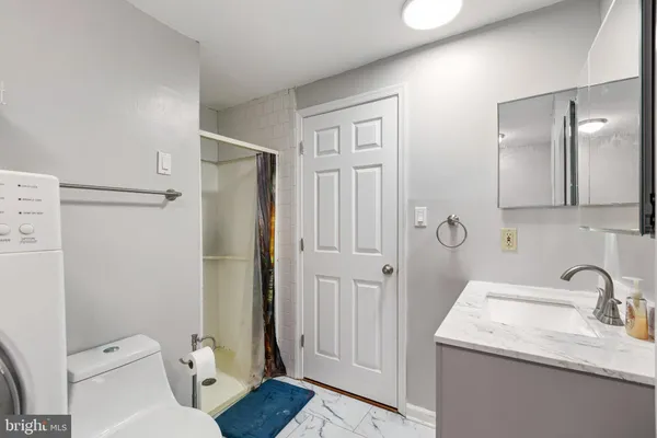 a bathroom with a granite countertop sink toilet and shower
