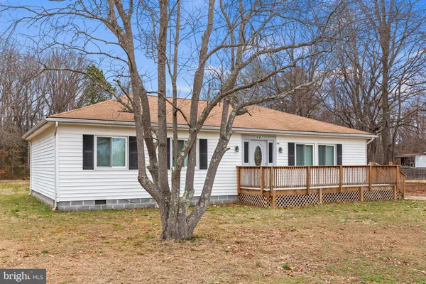 a front view of a house with a yard and large tree