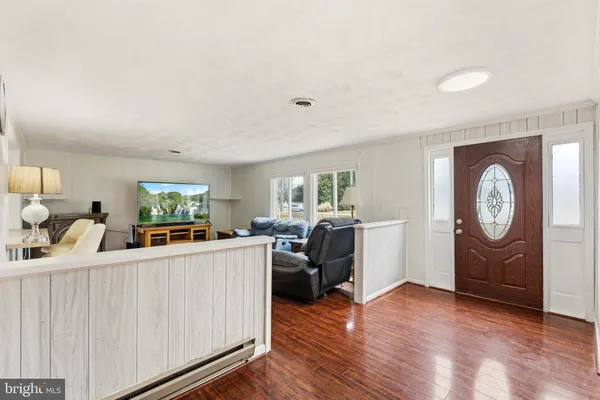 a living room with furniture a flat screen tv and a clock