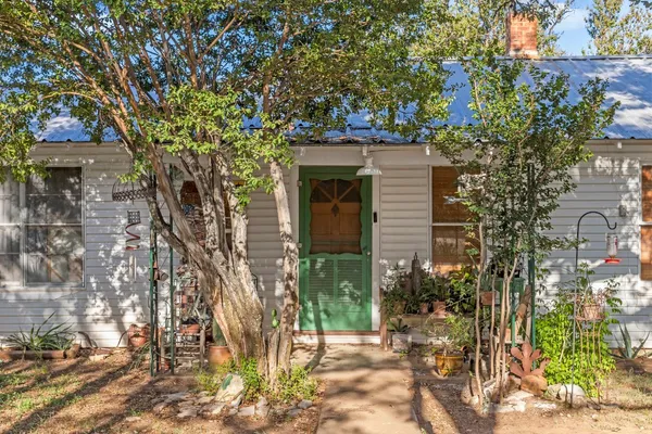 a front view of a house with a tree