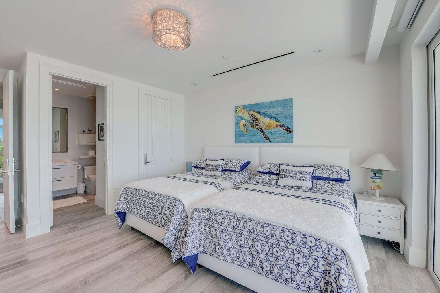 5001 Old Ocean Boulevard Ocean Ridge, FL 33435 - Photo 44 of 66 a bedroom with a bed and a chandelier