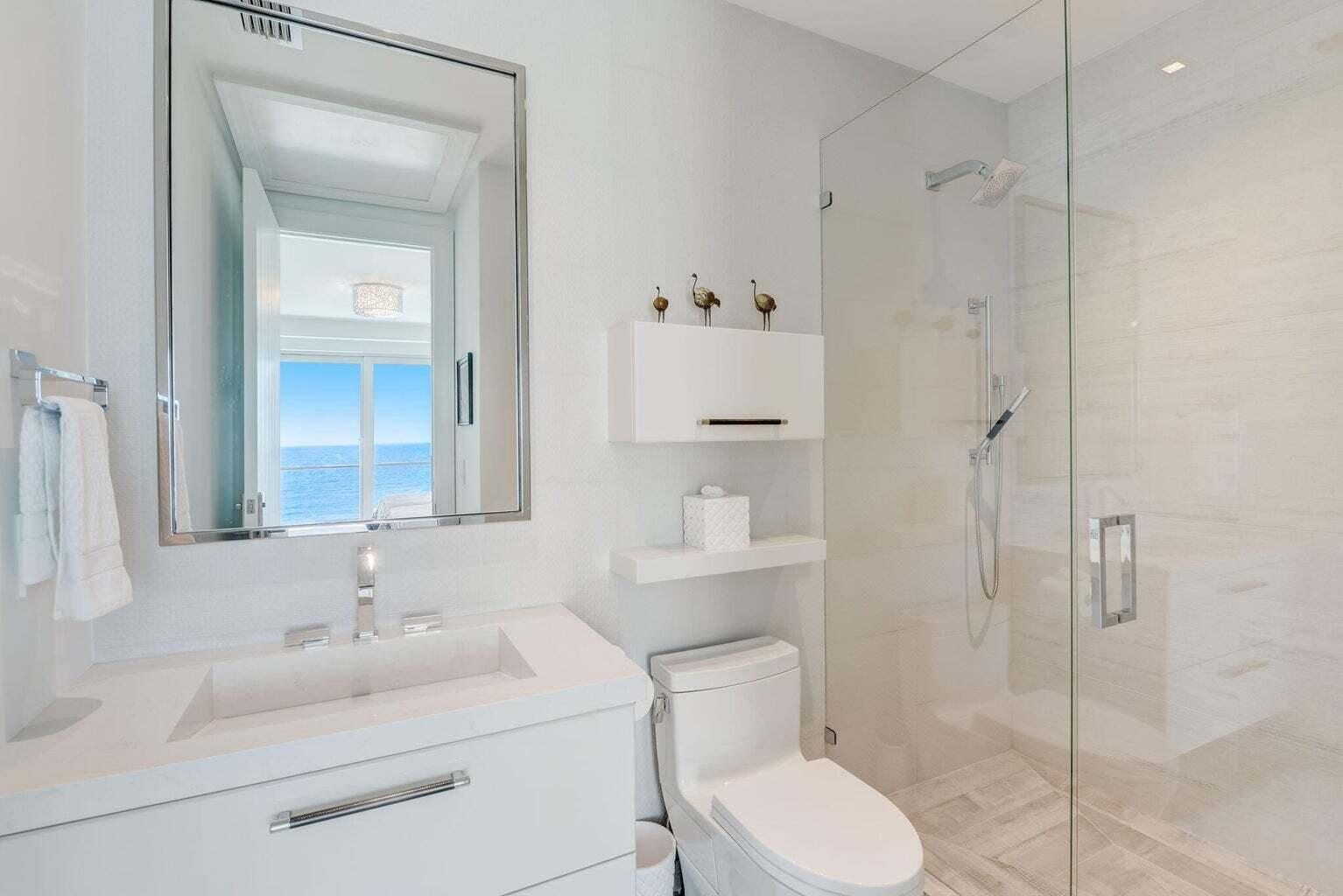 5001 Old Ocean Boulevard Ocean Ridge, FL 33435 - Photo 45 of 66 a bathroom with a toilet sink vanity and shower