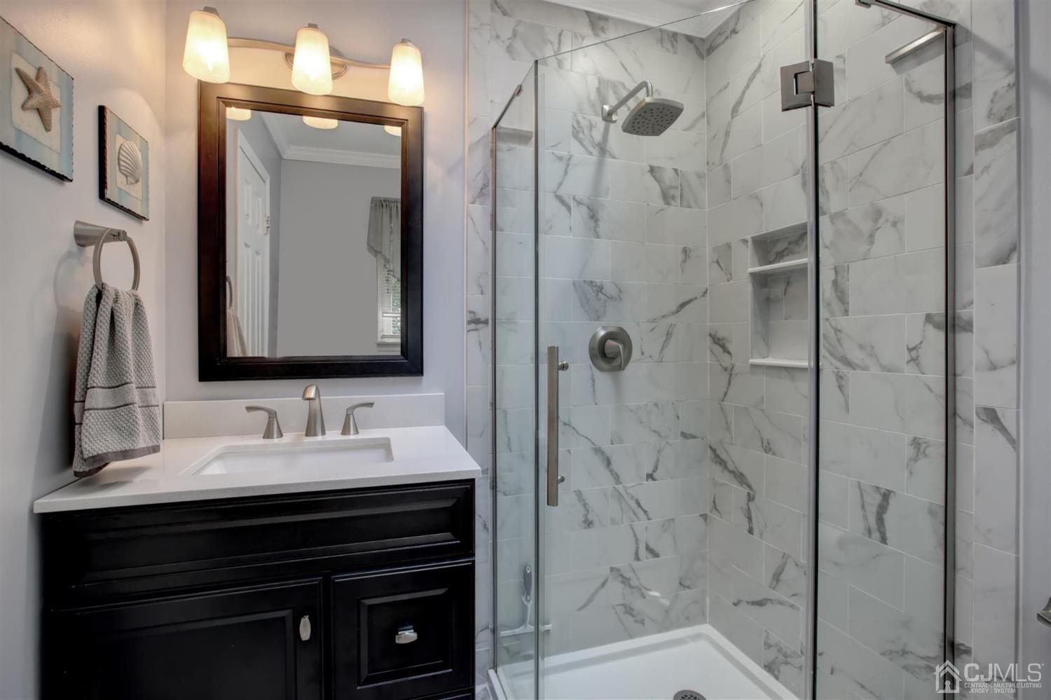 11 Walnut Court Old Bridge, NJ 07747 - Photo 21 of 32 a bathroom with a sink a mirror a vanity and shower