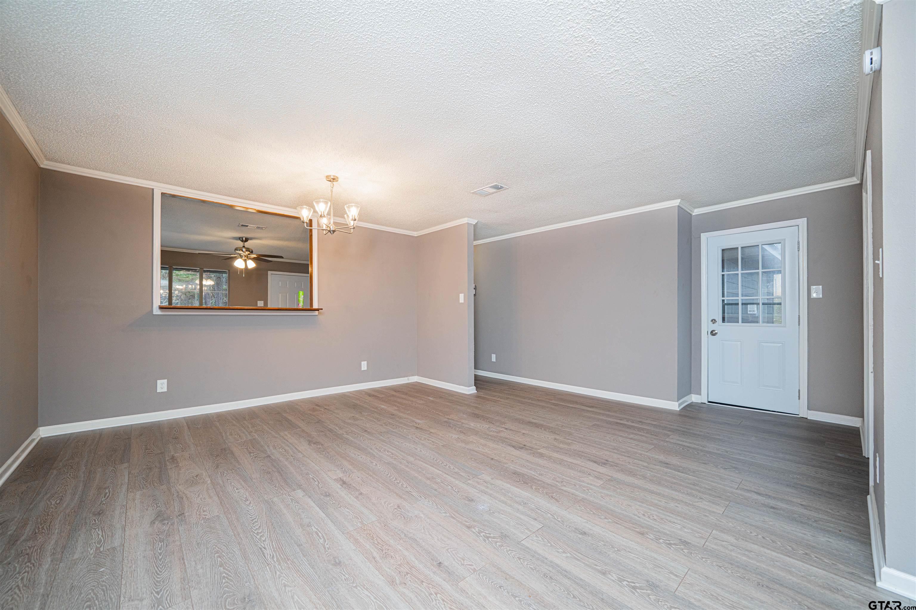 2802 Granite Drive Longview, TX 75604 - Photo 2 of 19 an empty room with wooden floor and windows