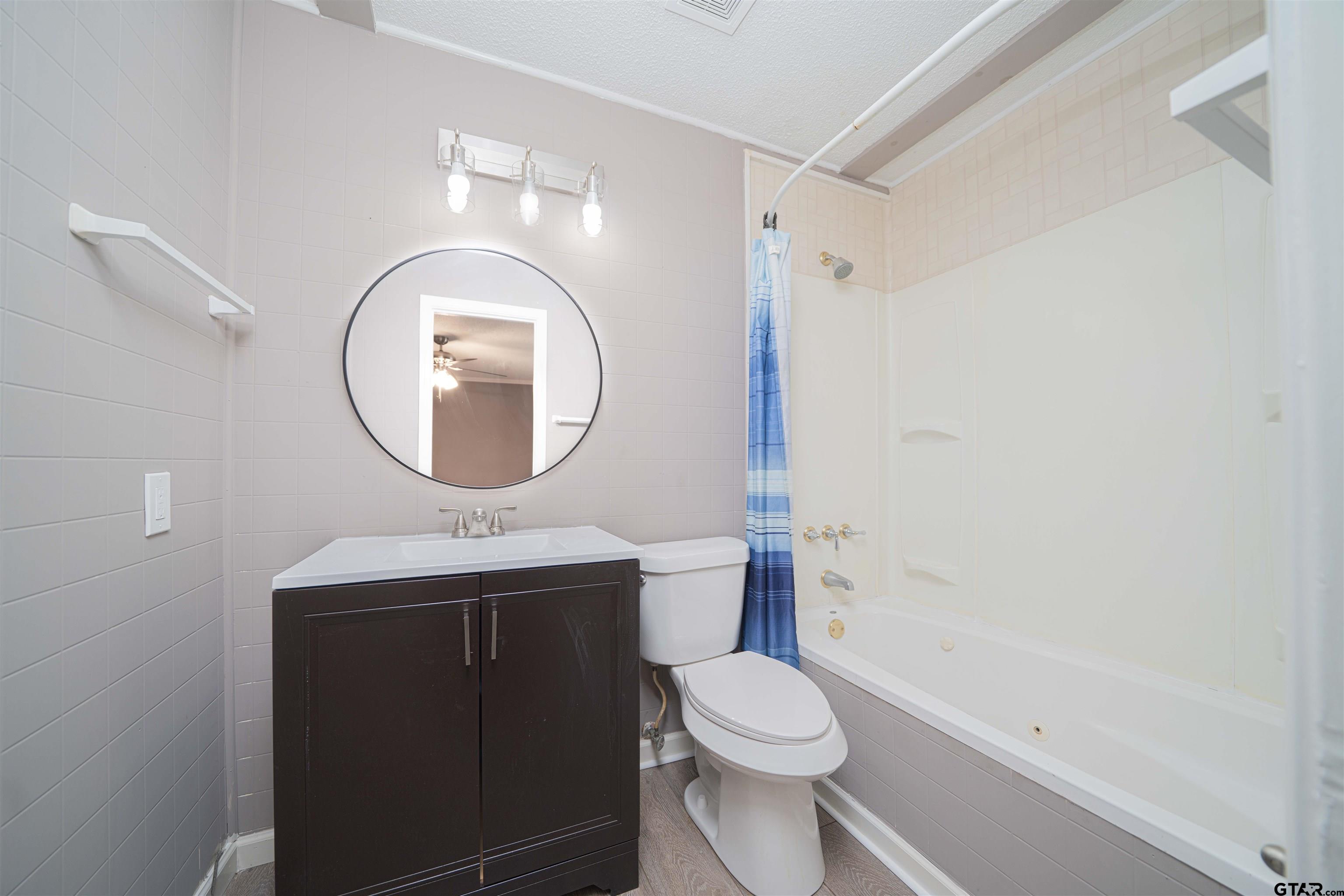 2802 Granite Drive Longview, TX 75604 - Photo 8 of 19 a bathroom with a toilet a sink and a mirror
