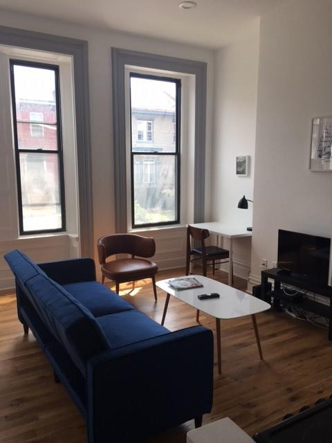 4407 Butler Street Pittsburgh, PA 15201 - Photo 14 of 29 a living room with a couch and a flat screen tv
