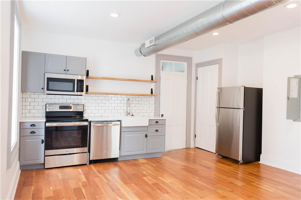 4407 Butler Street Pittsburgh, PA 15201 - Photo 24 of 29 a kitchen with cabinets stainless steel appliances and wooden floor