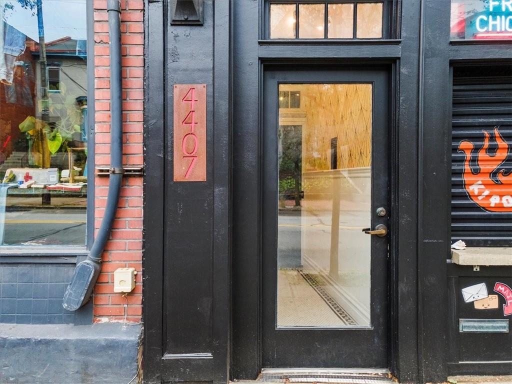 4407 Butler Street Pittsburgh, PA 15201 - Photo 6 of 29 a view of a brick house with a red door and a large window