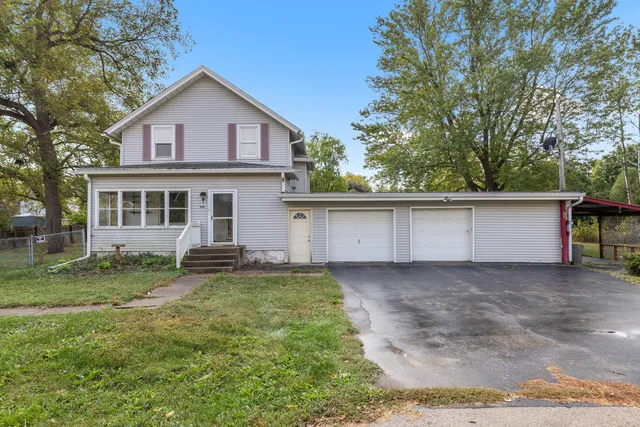 a view of a house with a yard and a large tree