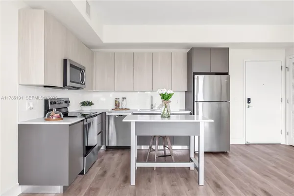 a kitchen with stainless steel appliances a refrigerator sink and white cabinets