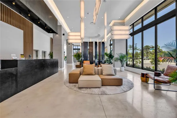 a living room with patio furniture and a large window