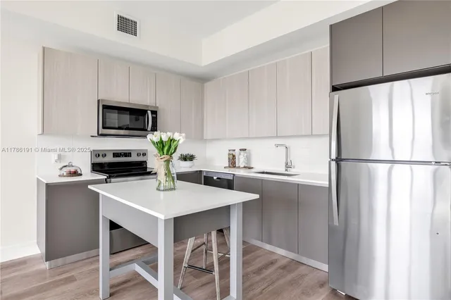 a kitchen with a refrigerator and a stove top oven