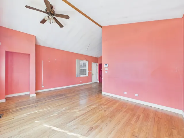a view of a big room with wooden floor and windows
