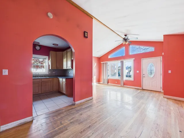 a view of a kitchen with a fridge and wooden floor