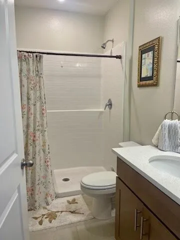a bathroom with a double vanity sink toilet and shower