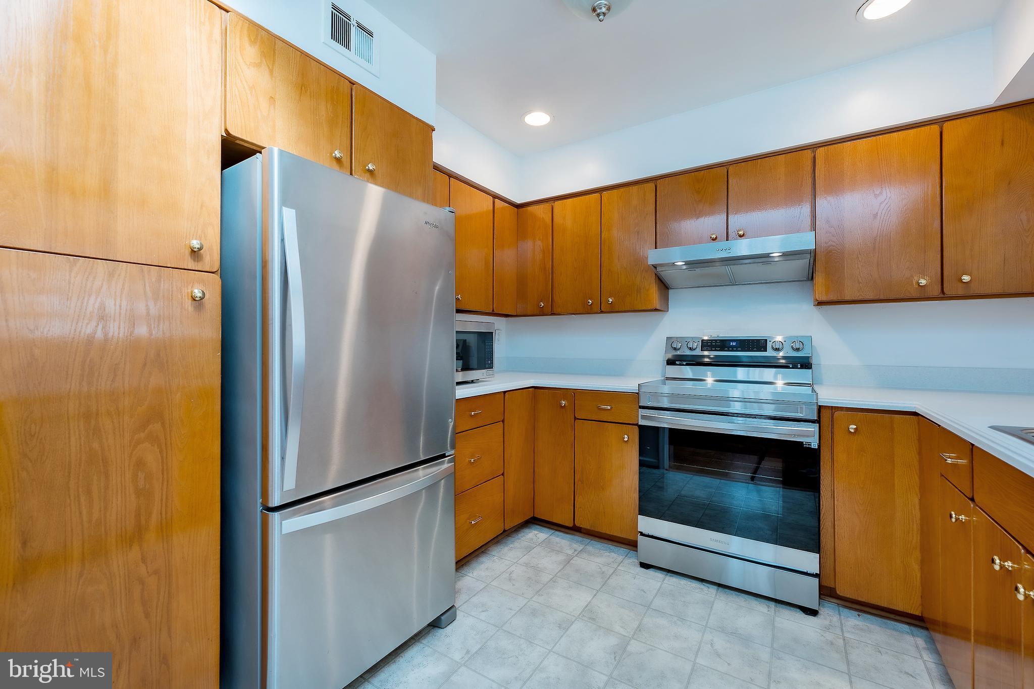 6504 Stratford Road Chevy Chase, MD 20815 - Photo 15 of 54 a kitchen with stainless steel appliances granite countertop a refrigerator a stove and a sink