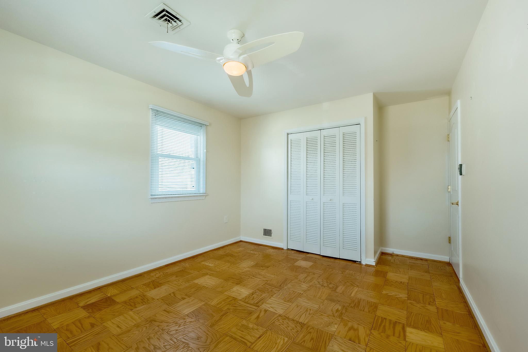 6504 Stratford Road Chevy Chase, MD 20815 - Photo 31 of 54 an empty room with a chandelier fan and windows