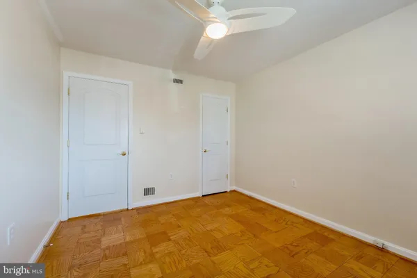 an empty room with windows and fan