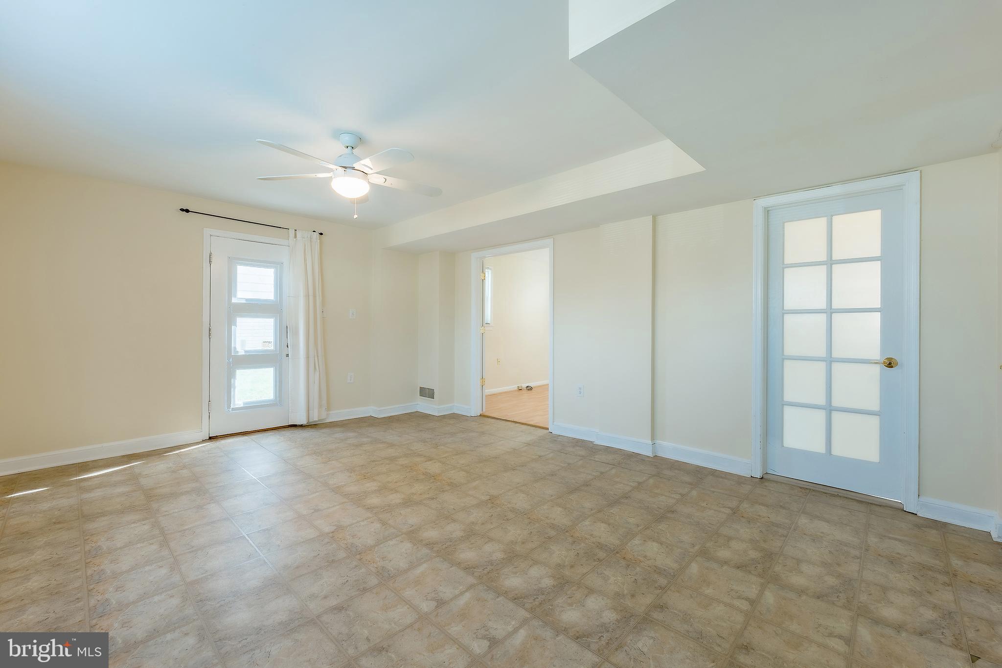 6504 Stratford Road Chevy Chase, MD 20815 - Photo 44 of 54 a view of an empty room with window and chandelier fan