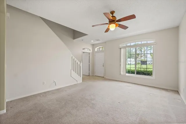 a view of a livingroom with a ceiling fan and window