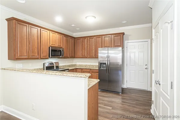 a kitchen with stainless steel appliances granite countertop a refrigerator a stove top oven a sink and dishwasher