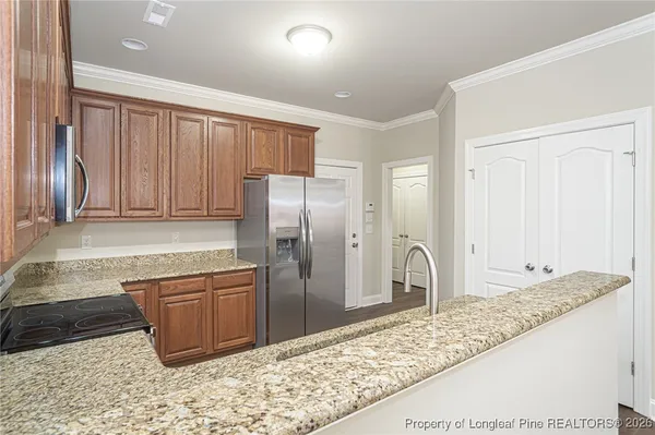 a kitchen with stainless steel appliances granite countertop a refrigerator and a sink
