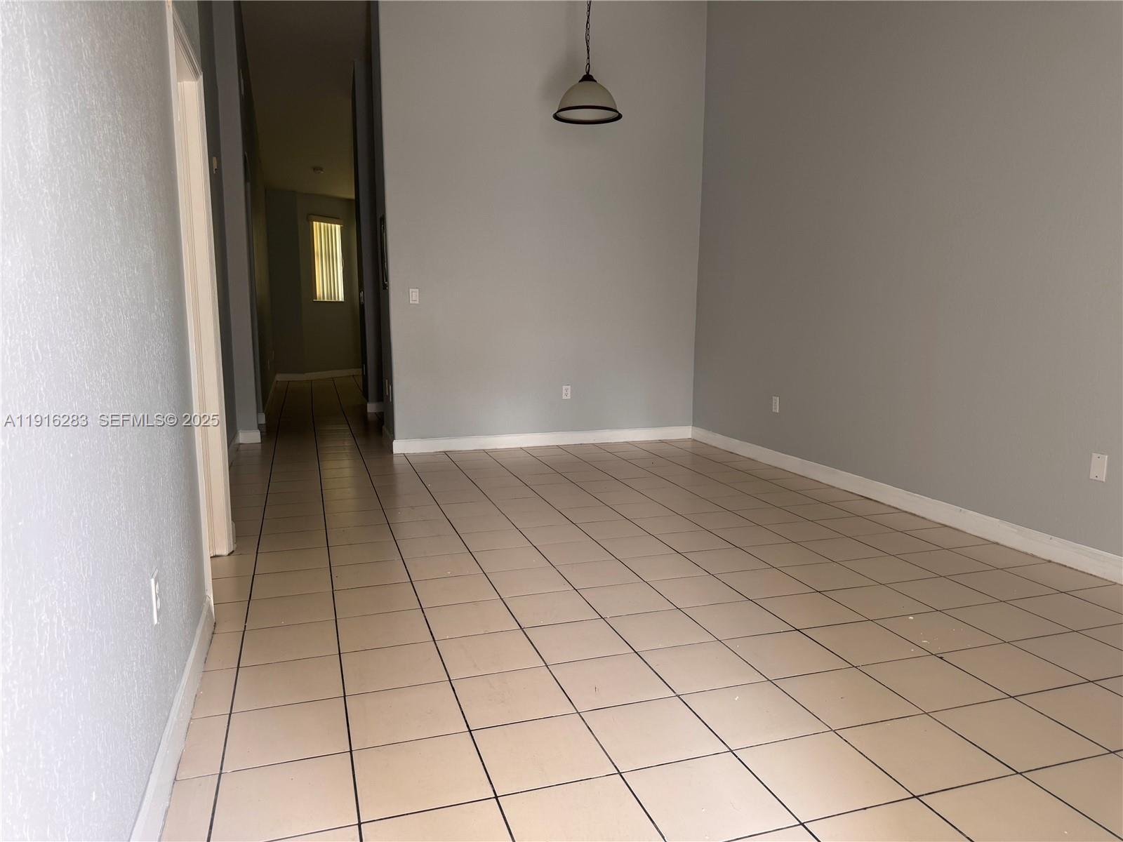 1663 Southeast 29th Street, Unit 202 Homestead, FL 33035 - Photo 6 of 9 a view of an empty room and wooden door