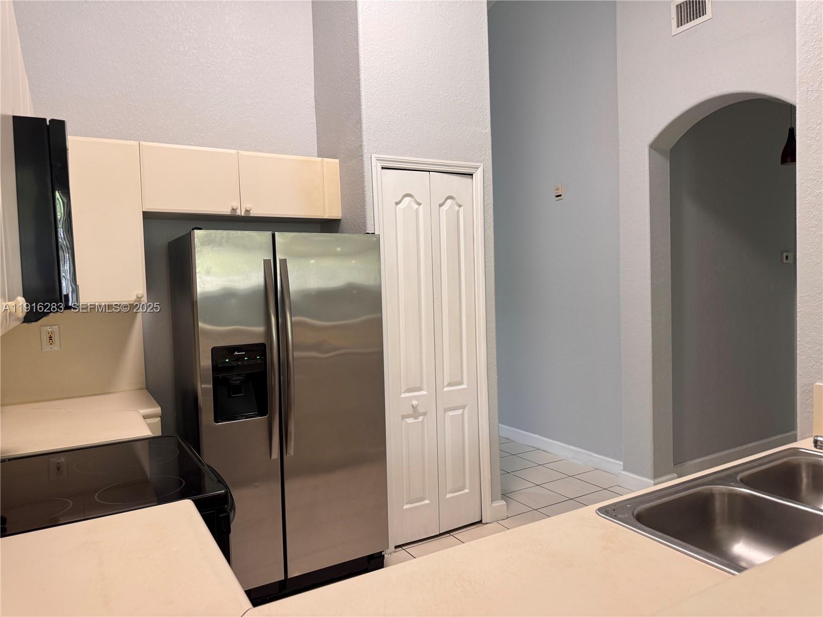 1663 Southeast 29th Street, Unit 202 Homestead, FL 33035 - Photo 7 of 9 a kitchen with a refrigerator and a sink