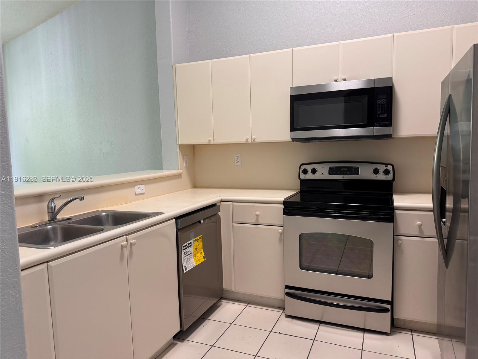 1663 Southeast 29th Street, Unit 202 Homestead, FL 33035 - Photo 8 of 9 a kitchen with white cabinets stainless steel appliances and sink