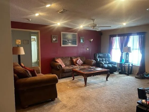 a living room with furniture a window and a flat screen tv