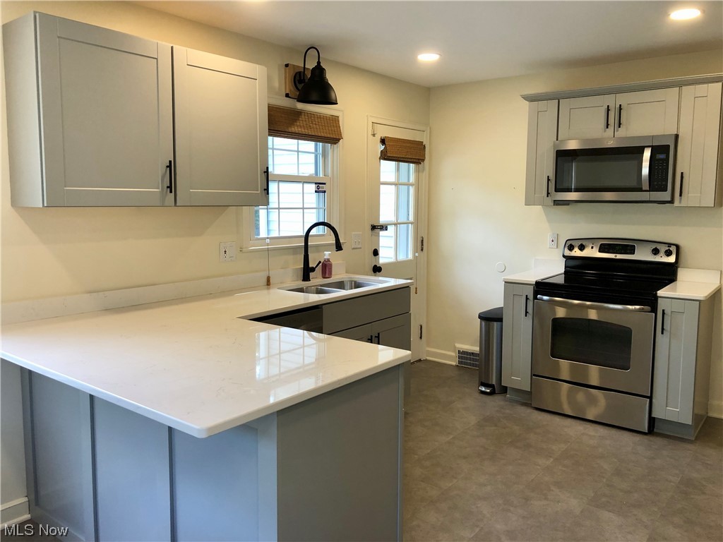 1246 Garman Road Akron, OH 44313 - Photo 10 of 22 Kitchen featuring stainless steel appliances, light countertops, and dark tile flooring