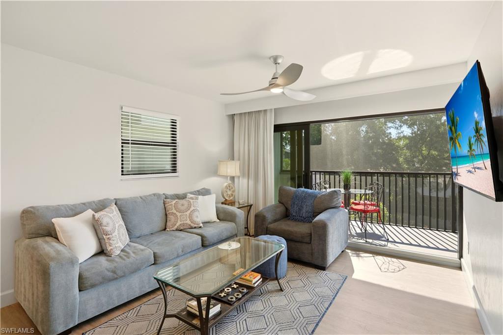 Living area with light wood finished floors, plenty of natural light, and ceiling fan