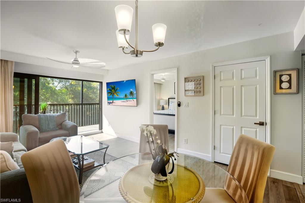 600 Neapolitan Way, Unit 254 Naples, FL 34103 - Photo 14 of 42 Living area featuring ceiling fan, wood finished floors, and suspended lighting