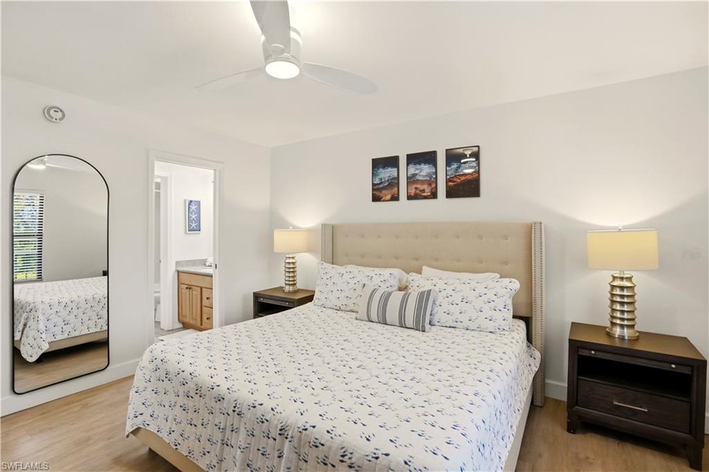 600 Neapolitan Way, Unit 254 Naples, FL 34103 - Photo 19 of 42 Bedroom featuring ensuite bathroom, light wood-style floors, and ceiling fan