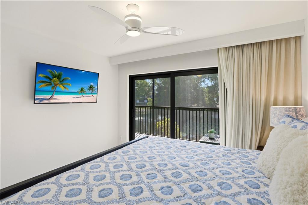600 Neapolitan Way, Unit 254 Naples, FL 34103 - Photo 23 of 42 Bedroom featuring access to outside and a ceiling fan