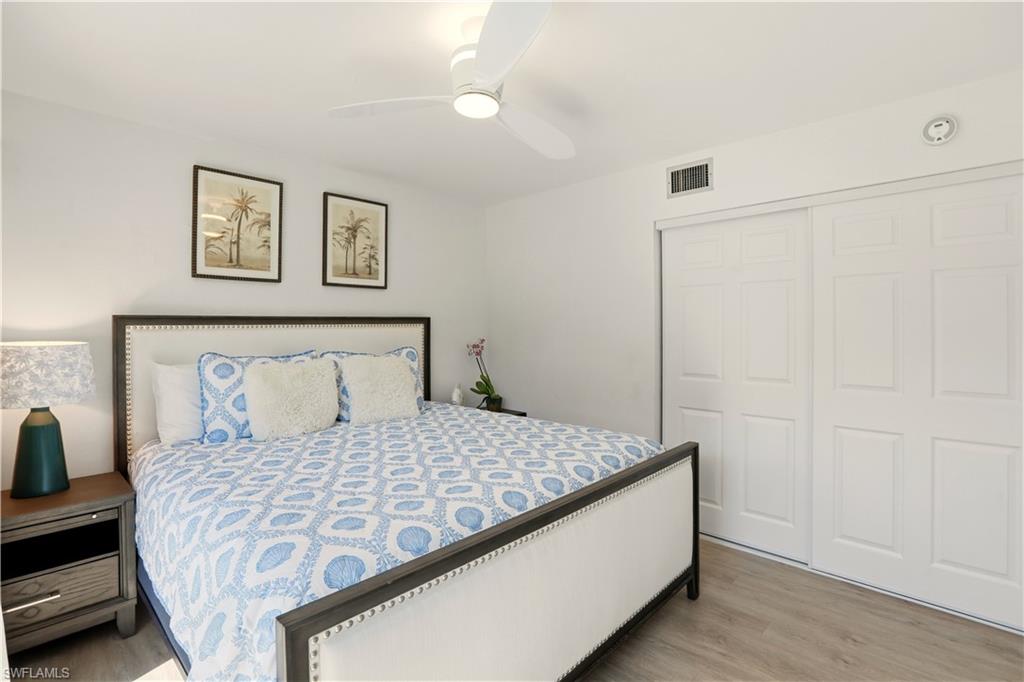 600 Neapolitan Way, Unit 254 Naples, FL 34103 - Photo 25 of 42 Bedroom with a closet, light wood finished floors, and ceiling fan