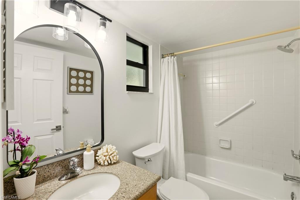 600 Neapolitan Way, Unit 254 Naples, FL 34103 - Photo 26 of 42 Bathroom featuring vanity and shower / bathtub combination with curtain
