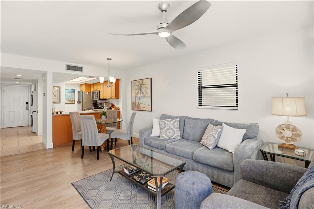 600 Neapolitan Way, Unit 254 Naples, FL 34103 - Photo 3 of 42 Living area featuring light wood-style flooring, ceiling fan, and suspended lighting