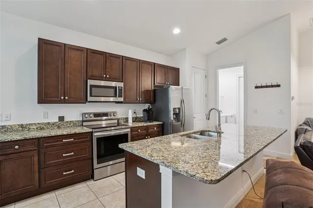 a kitchen with a sink a stove a microwave and refrigerator