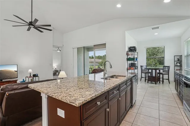 a kitchen with granite countertop kitchen island a table and chairs in it