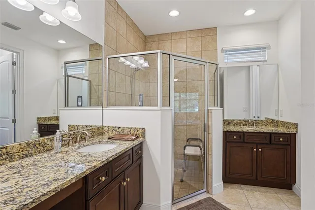 a bathroom with a granite countertop sink a mirror and a shower
