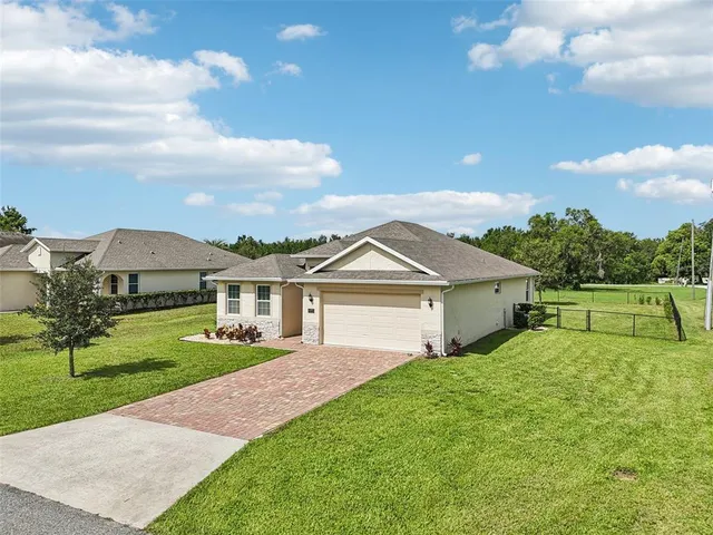 a view of a house with a big yard and a large trees