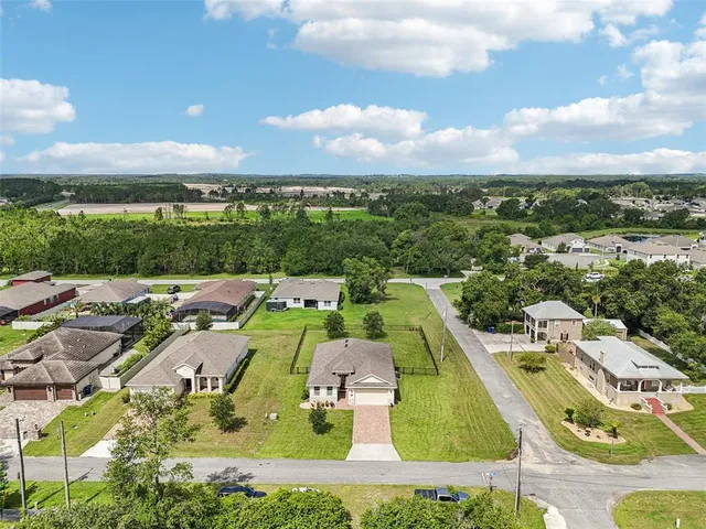 an aerial view of a house with a big yard