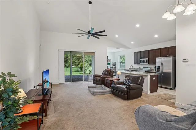 a living room with furniture a chandelier and a window