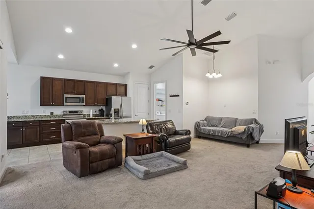 a living room with furniture kitchen view and a chandelier
